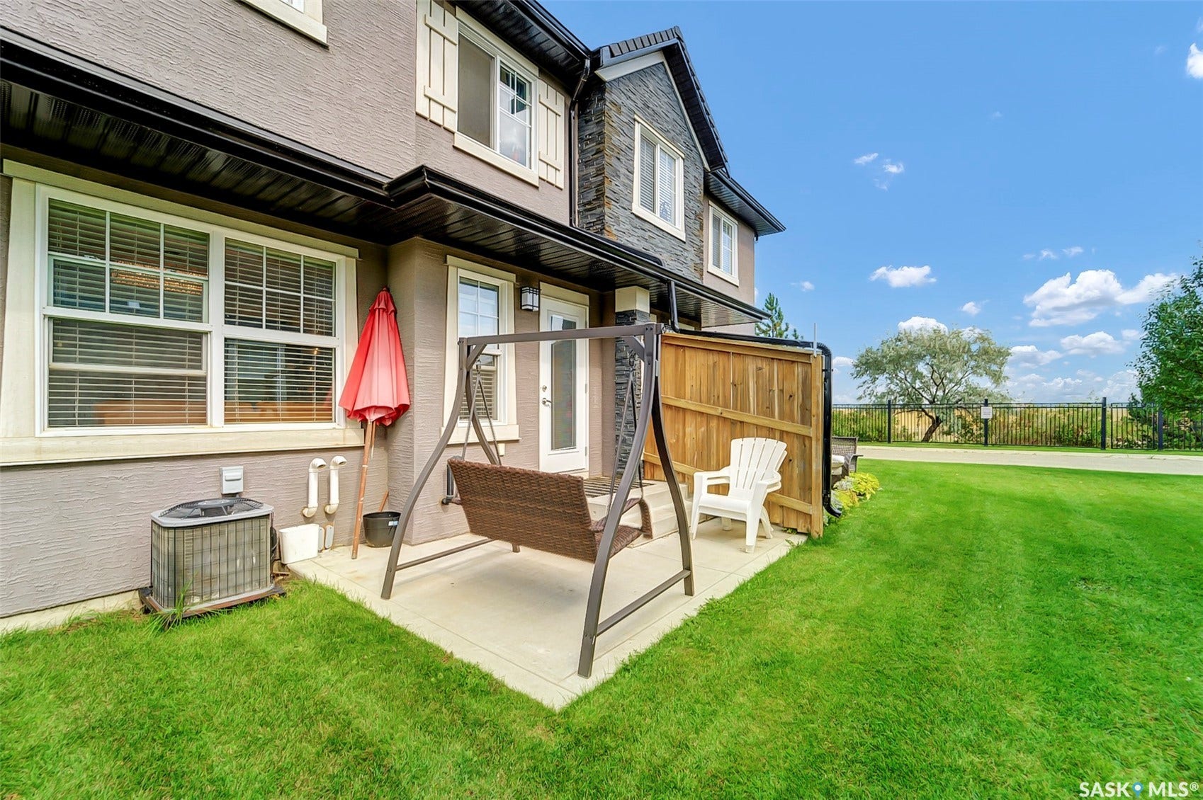 Private patio with concrete surfacing, bordered by a wooden fence