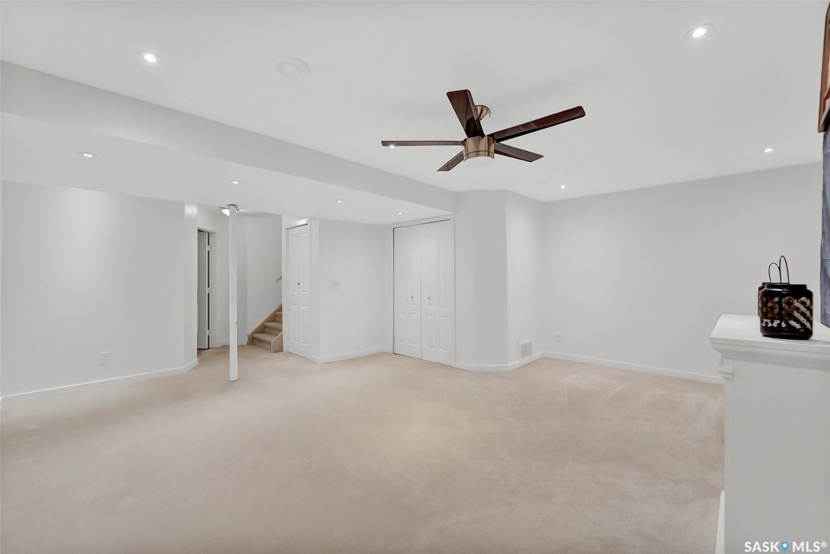 Recessed lighting, ceiling fan, neutral wall paint, light-toned carpeting, and bi-fold closet doors
