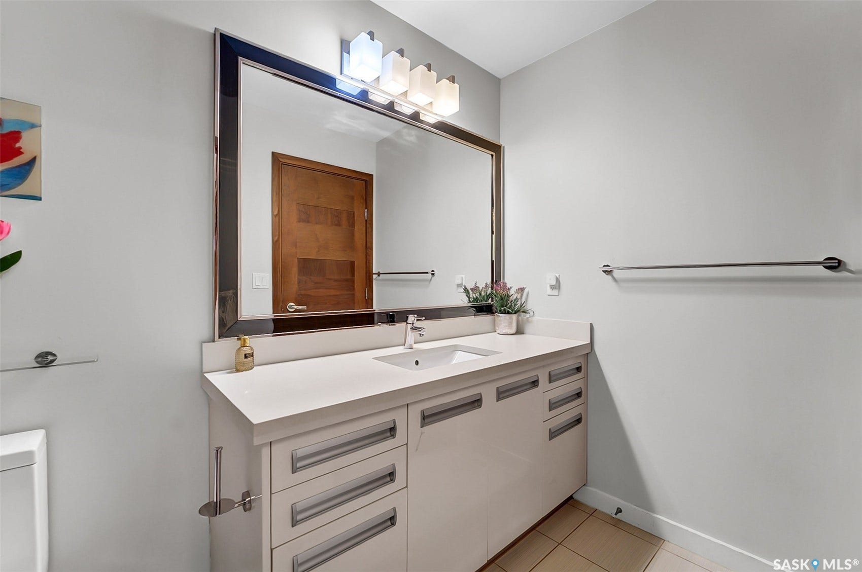 Integrated vanity with a single basin sink, white countertop, and extensive storage cabinetry