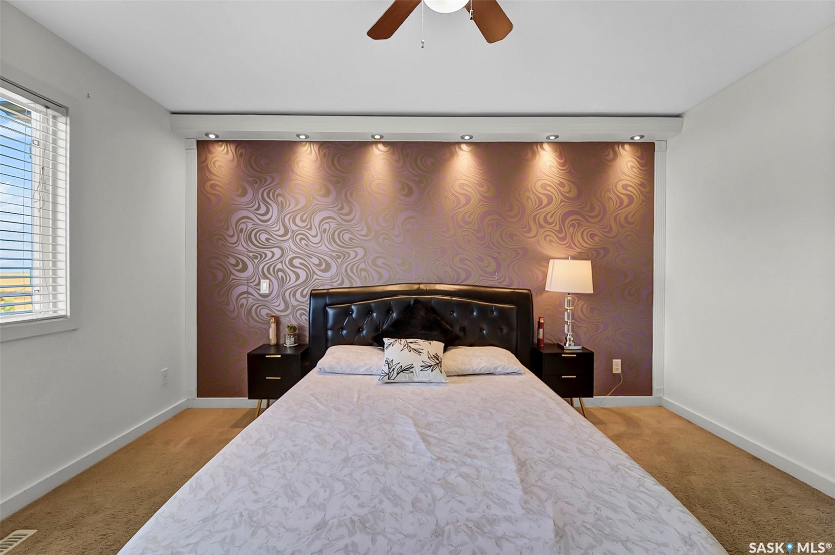Textured accent wall with recessed lighting, ceiling fan, and carpeted flooring