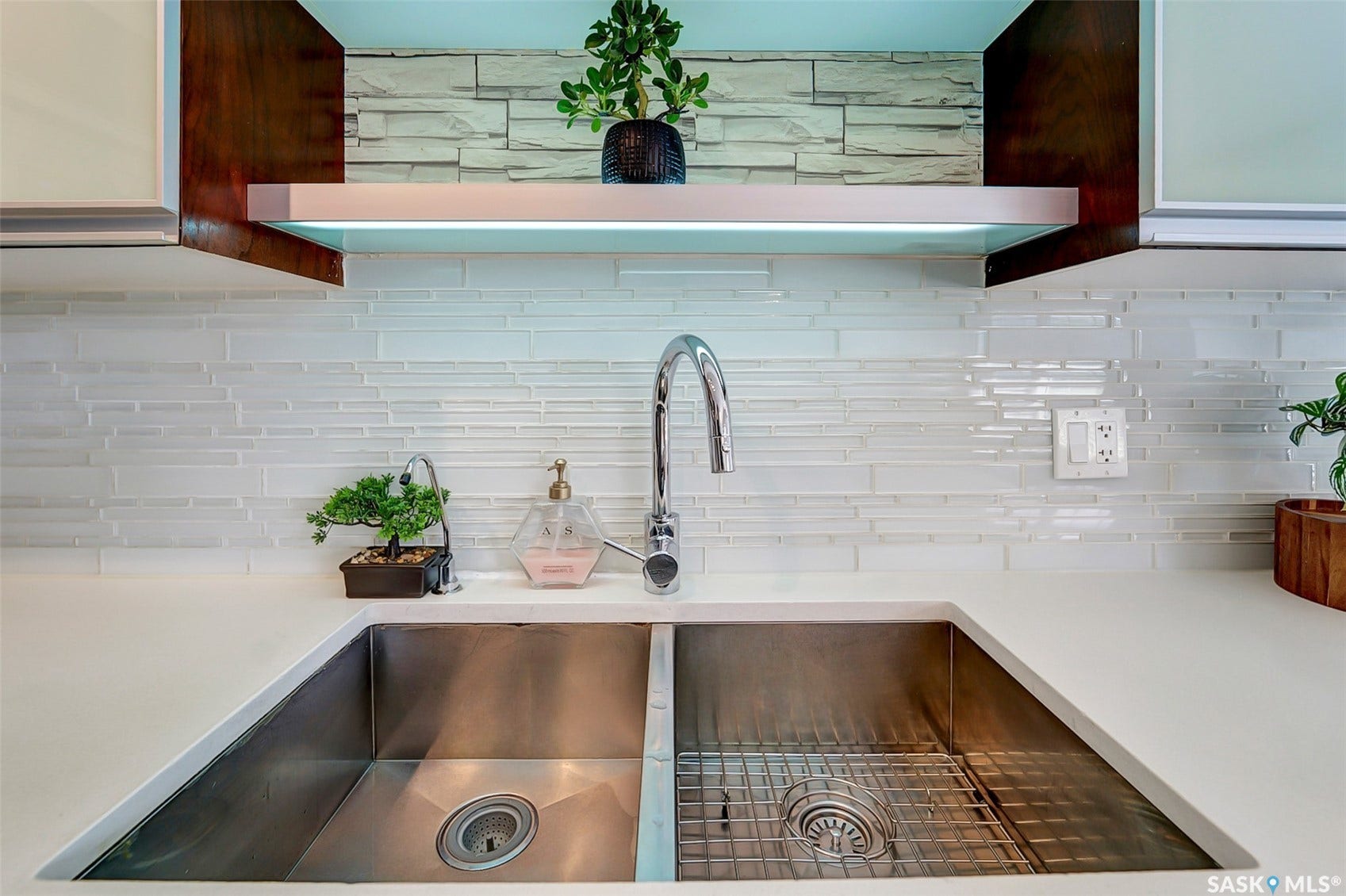 Stainless steel undermount double sink with a high-arc chrome faucet, set into a light-toned countertop