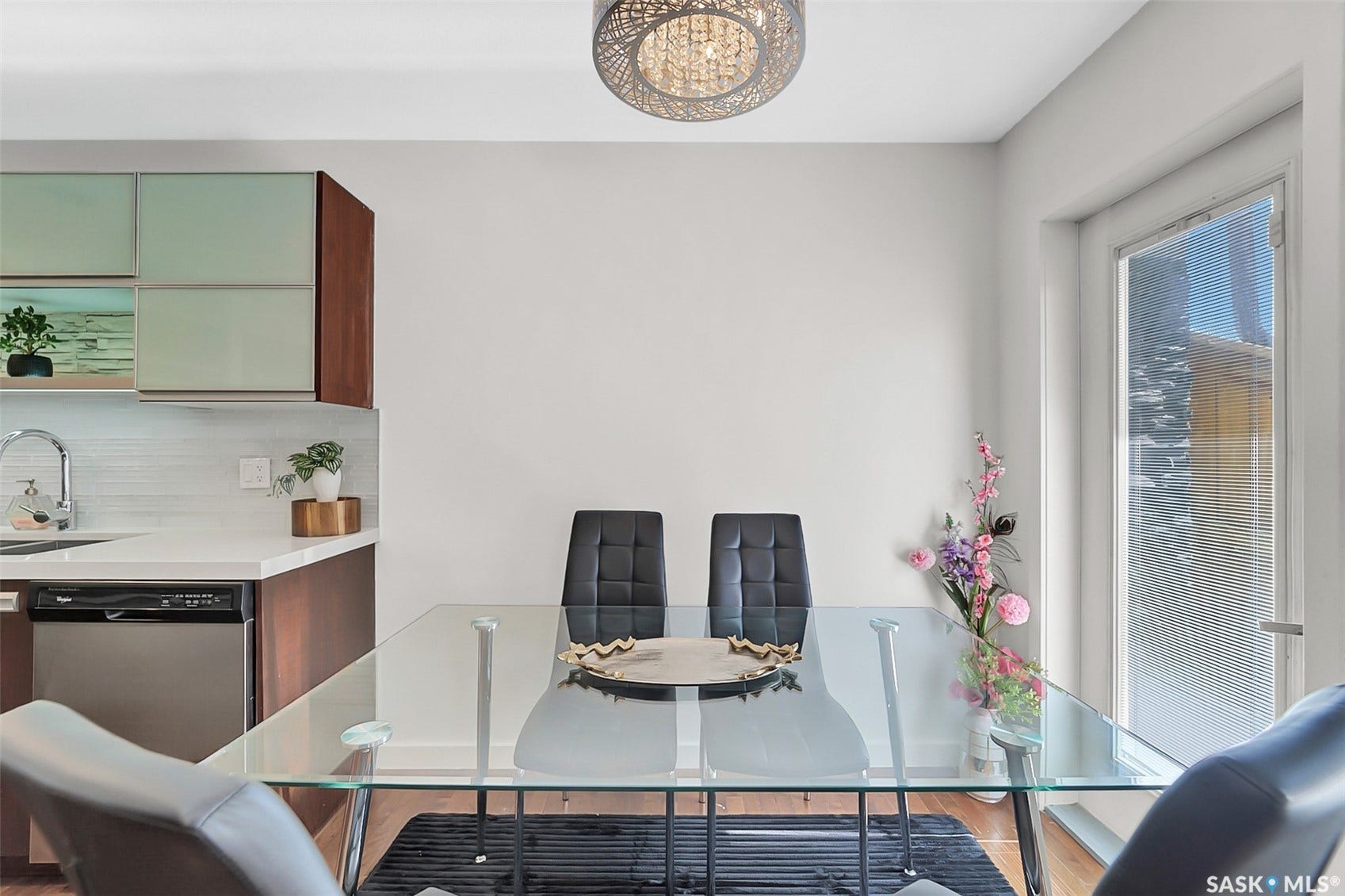 Modern kitchen with sleek cabinetry, white countertops, stainless steel dishwasher, and a contemporary ceiling fixture