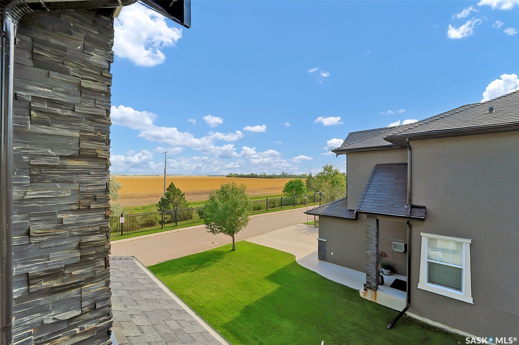 Exterior featuring stone cladding, stucco finish, shingle roofing, and a paved driveway