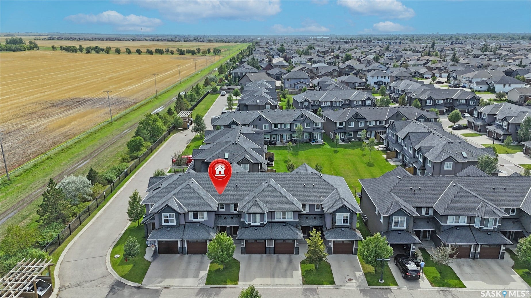 Modern townhome with a dark gray exterior, attached garage, and paved driveway