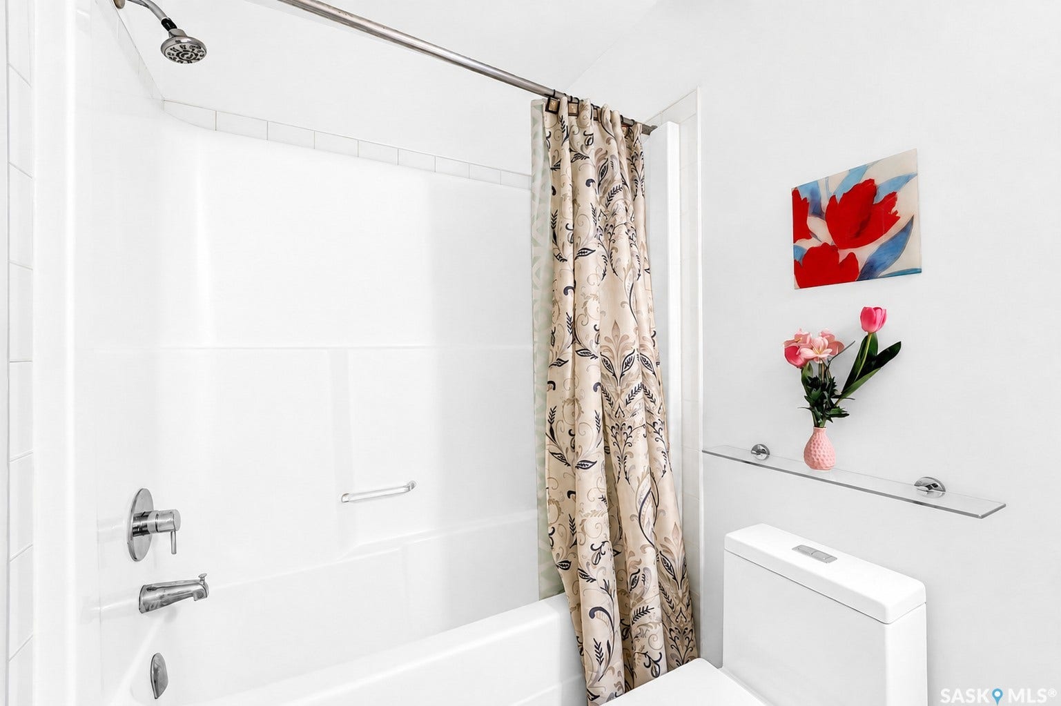 Bathtub with an integrated shower, white tiled surround, and chrome fixtures