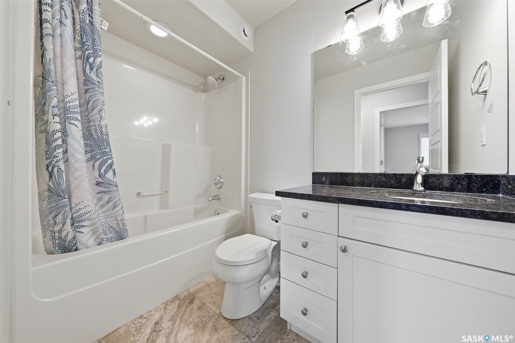 White vanity with dark stone countertop, undermount sink, and chrome faucet