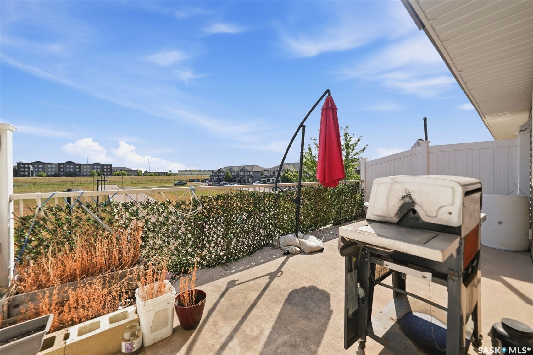 Paved patio area featuring a privacy screen and partial fencing