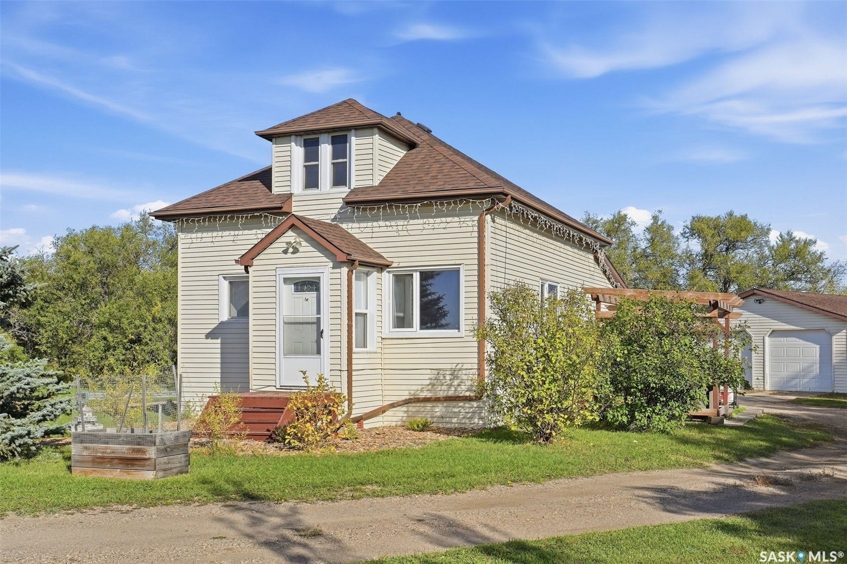 Vinyl siding exterior with a pitched roof and a detached garage
