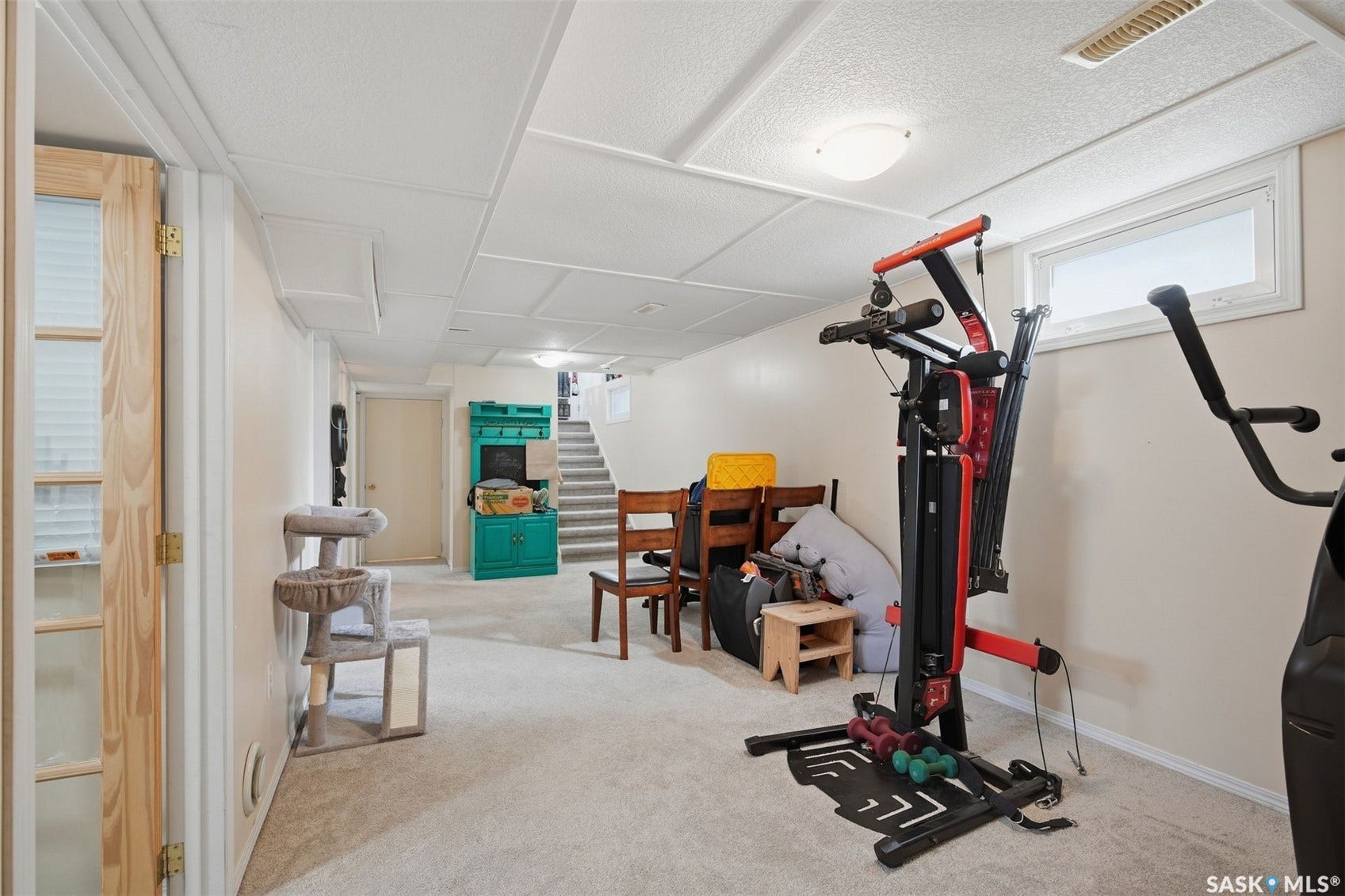 Finished basement with carpet flooring, light-toned walls, and a drop ceiling with recessed lighting
