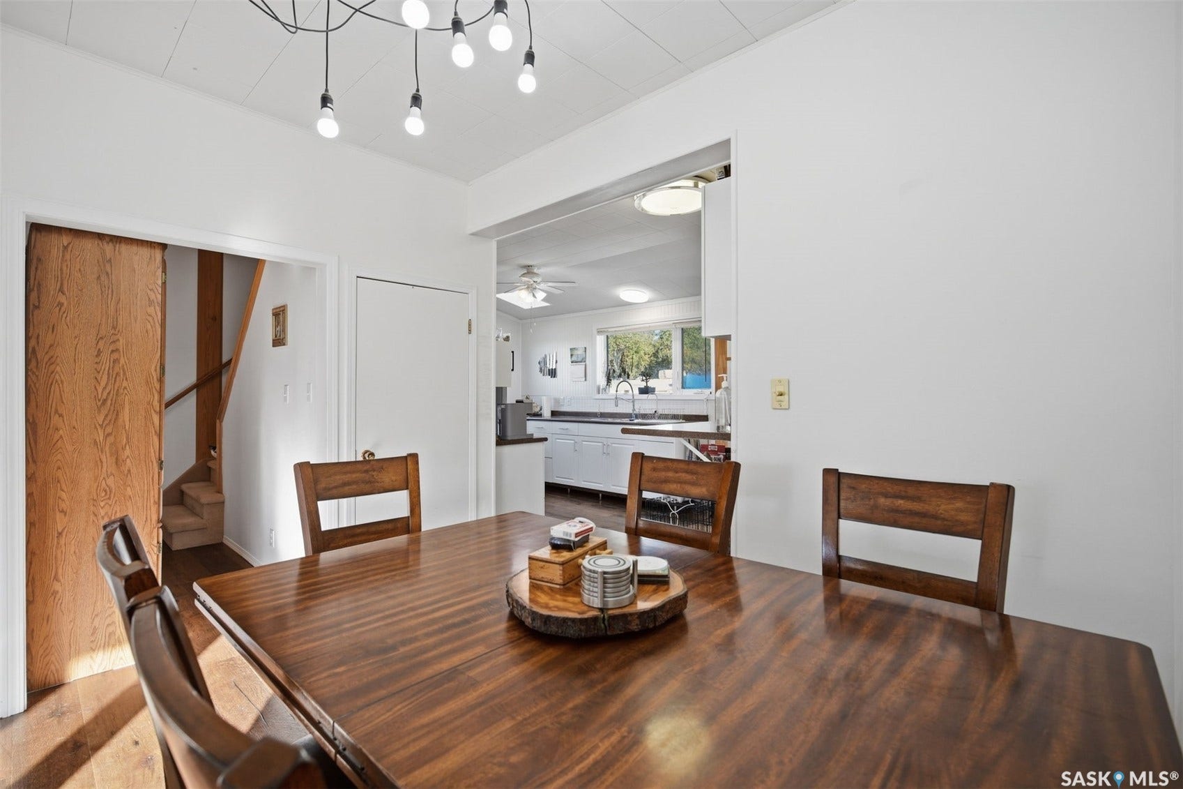 Wood-finish flooring, white walls, and a modern ceiling light fixture