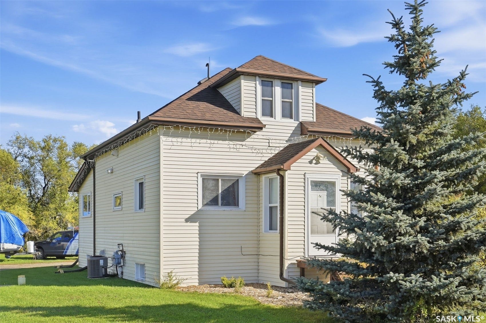 Dormer windows, light-colored siding, and a gabled roofline
