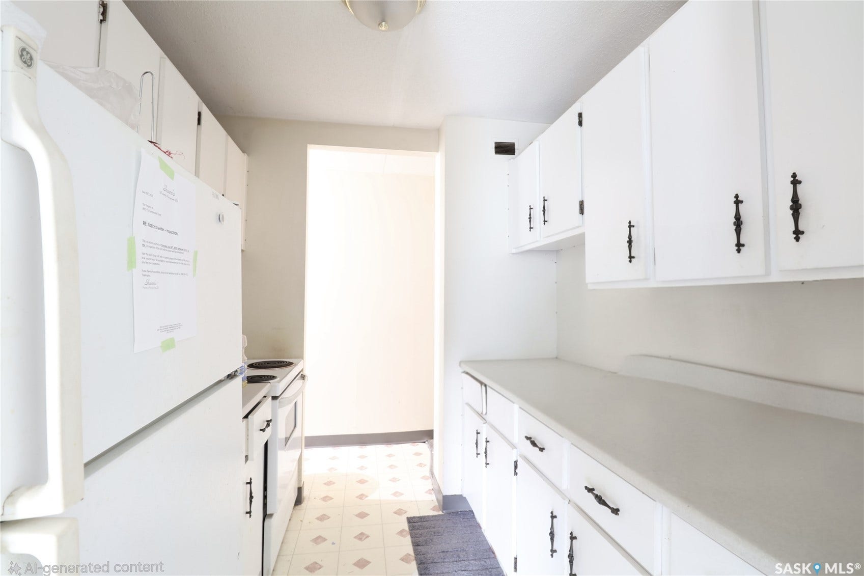 Kitchen featuring white upper and lower cabinetry, ample countertop space, and patterned floor tiles