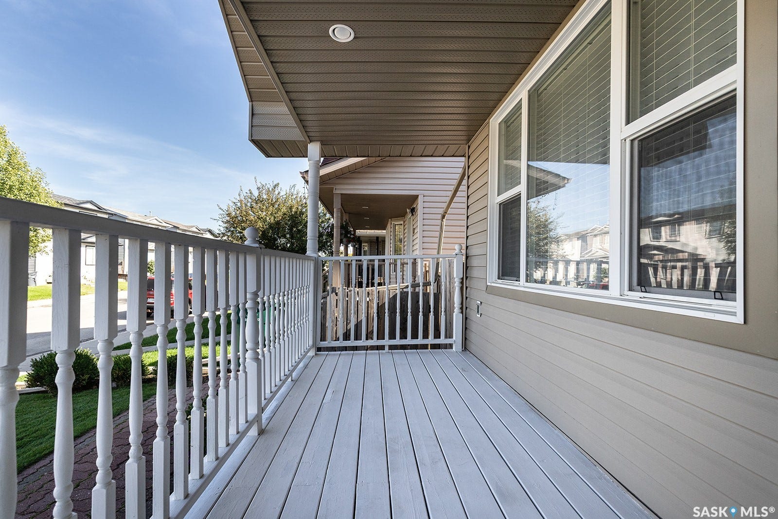 Expansive front porch featuring white railings and a composite deck