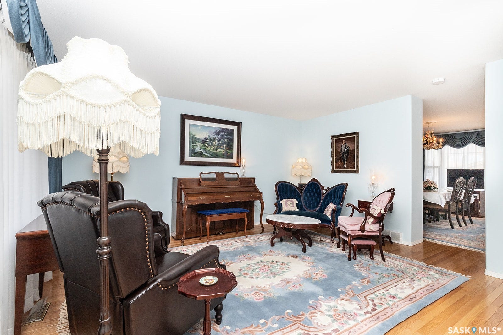 Featuring hardwood flooring and a large window with valance and drapes