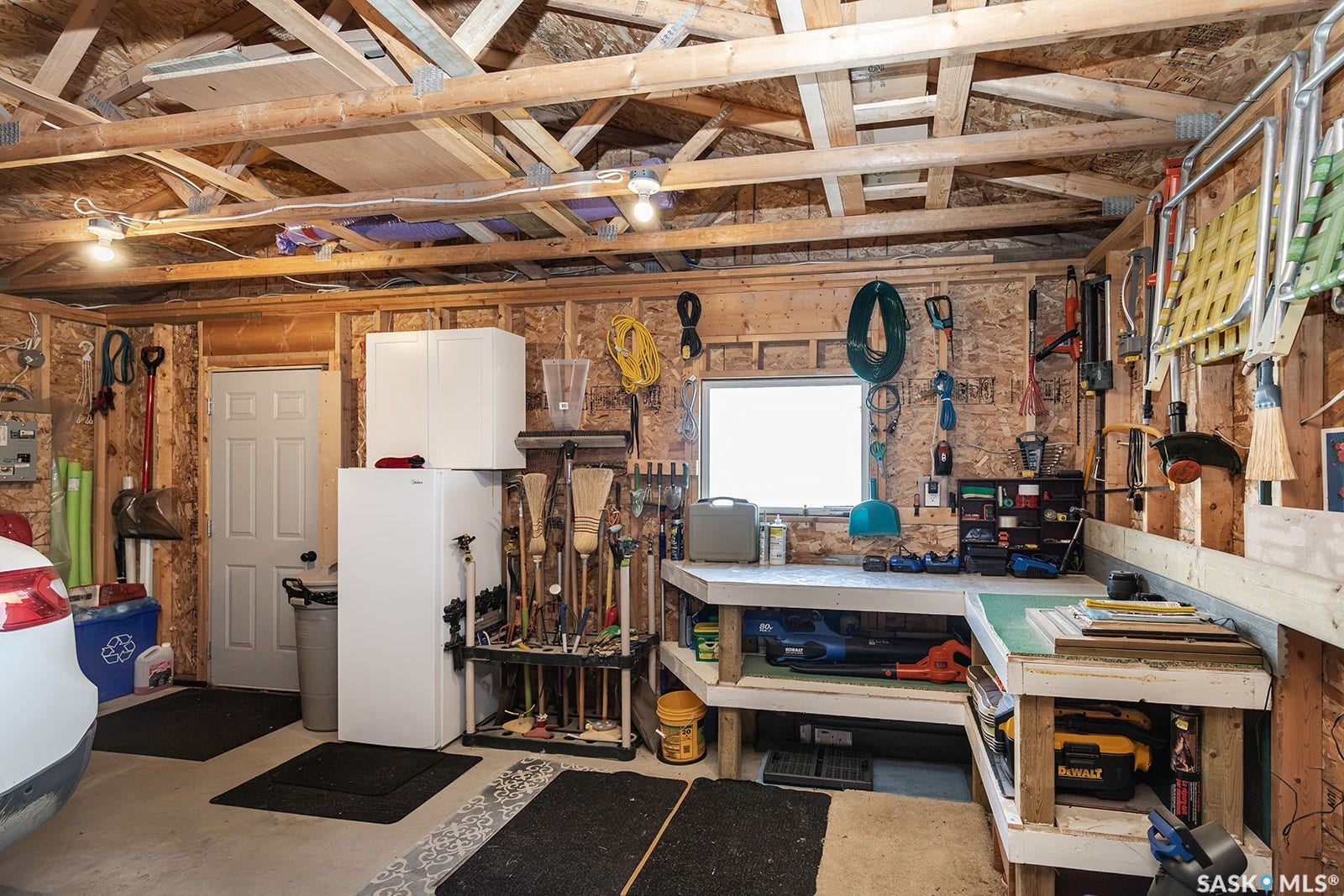 Detached double garage with exposed wood beam ceiling and built-in workbench
