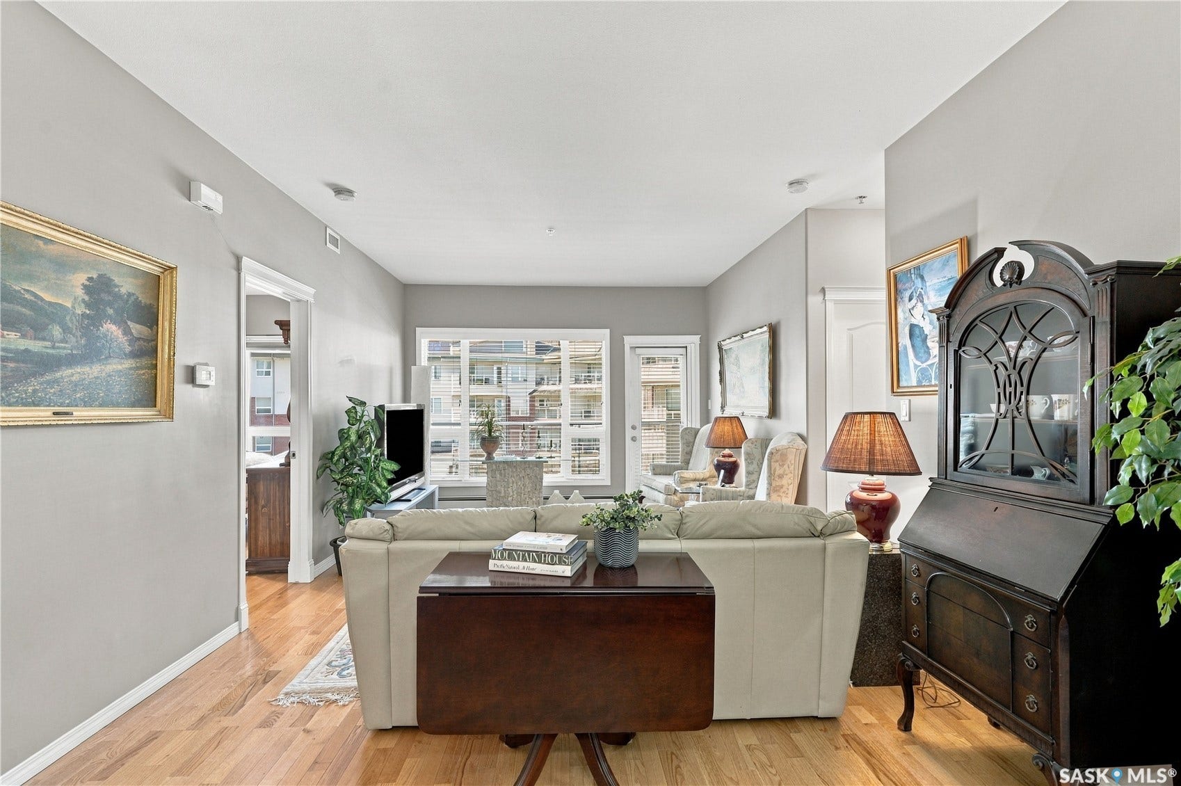 Hardwood flooring throughout, neutral wall tones, multi-pane windows with white trim, recessed lighting, and a white interior door frame