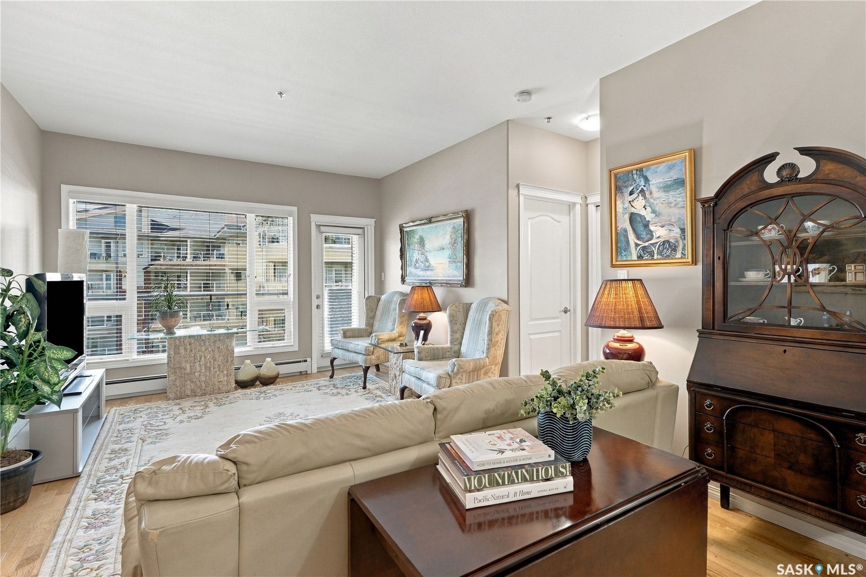 Hardwood-style flooring, expansive windows, light-toned wall finishes, and a contemporary glass-paneled door