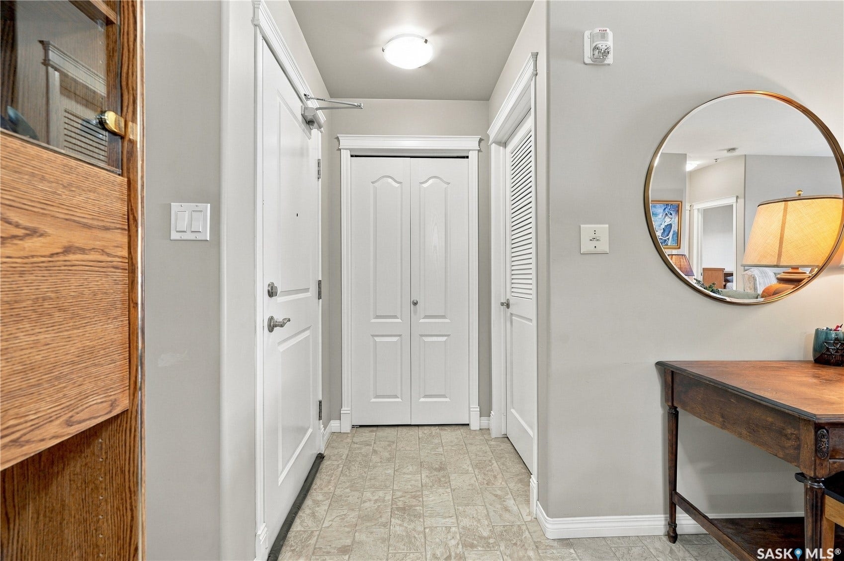 Entrance hall featuring light gray wall paint, white trim, and resilient tile flooring