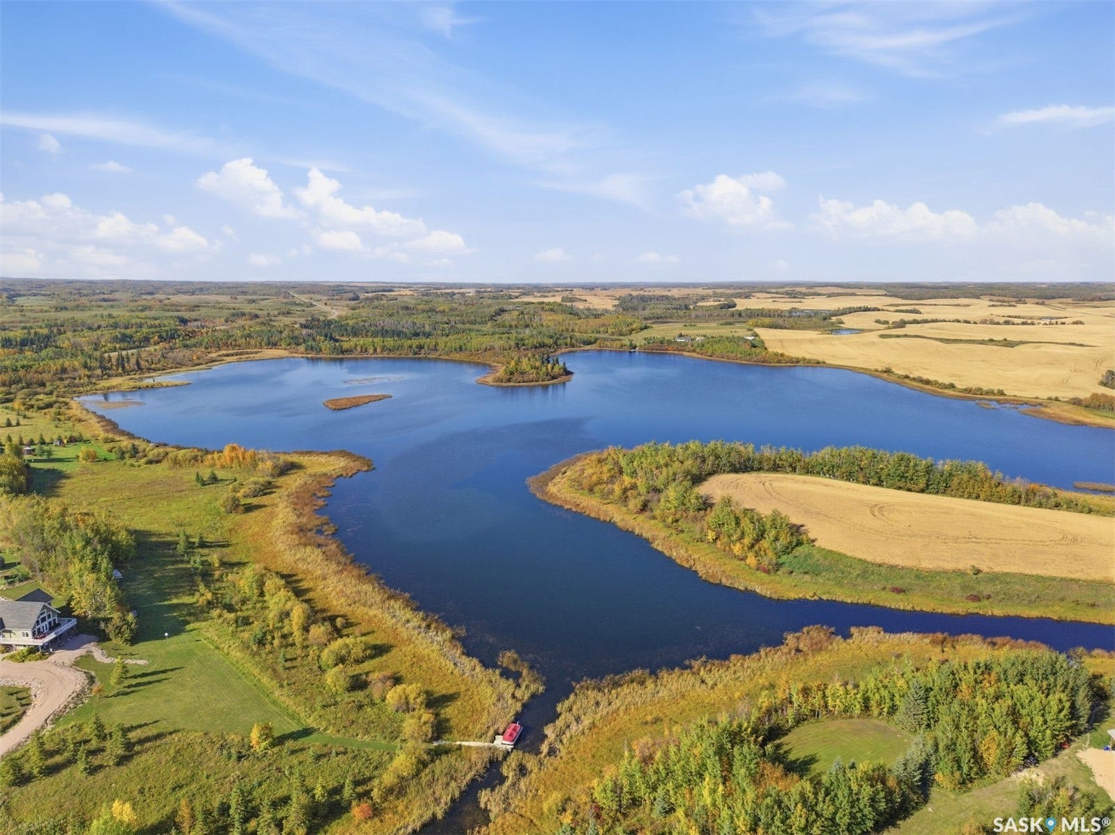 Expansive lake frontage with a private dock and a structure by the water