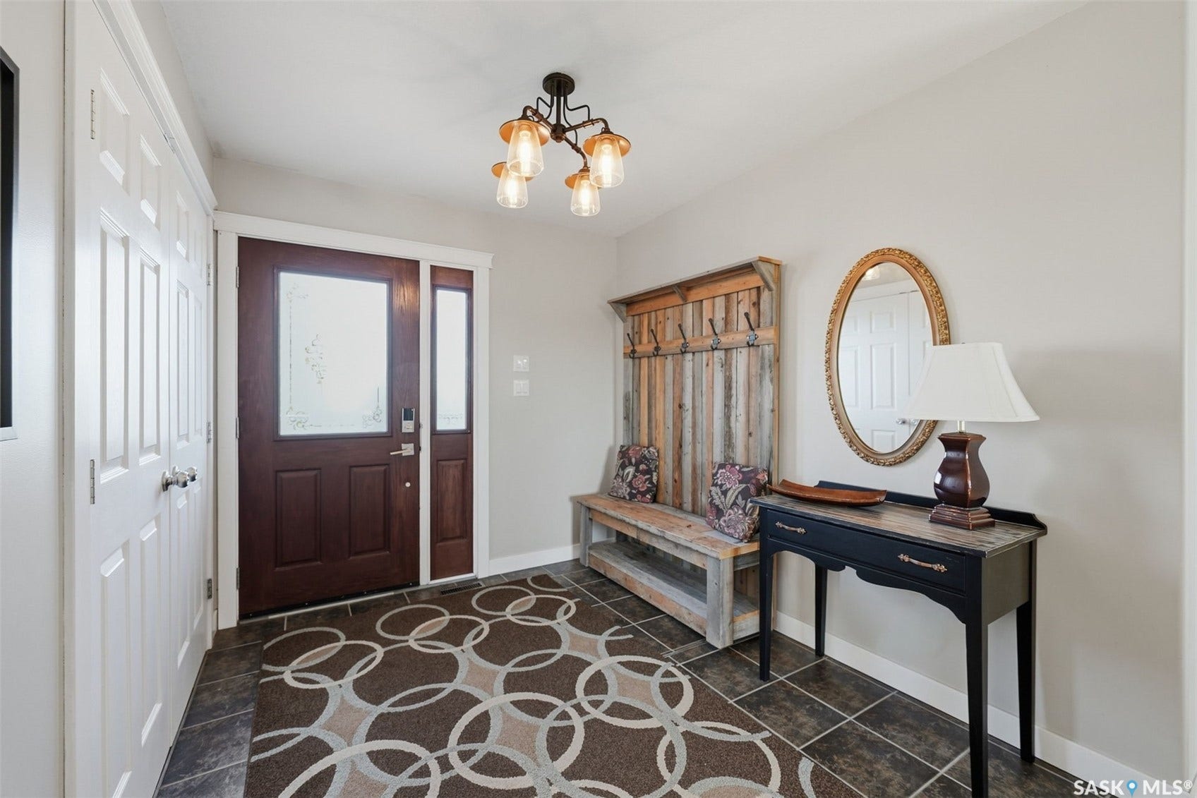 Entryway featuring a dark wood-finish door with frosted glass, side-lite, and slate-style floor tile
