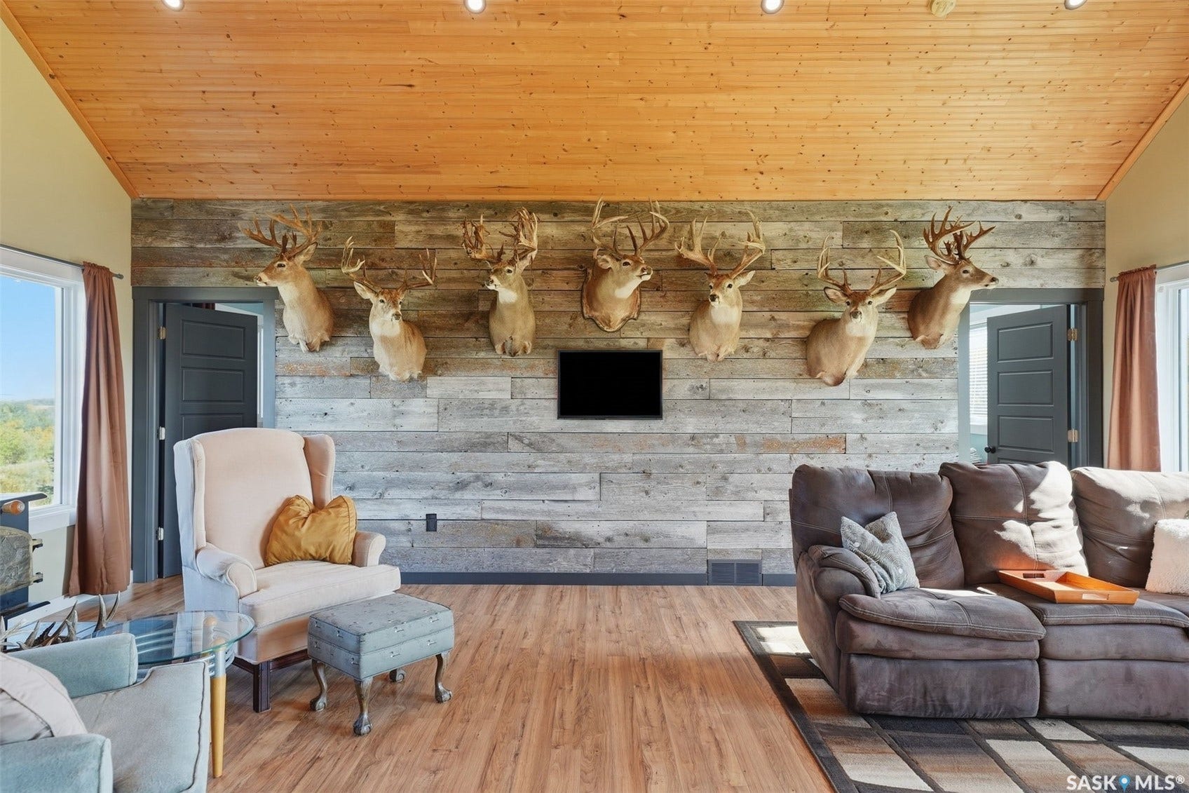 Wood-finish flooring, wood plank ceiling, and a reclaimed wood accent wall create a distinctive interior