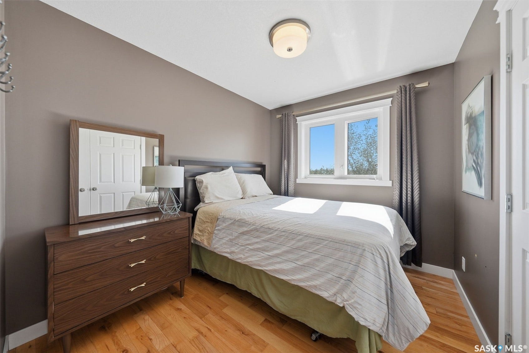 Hardwood flooring, painted walls, white trim, and a double-paned window