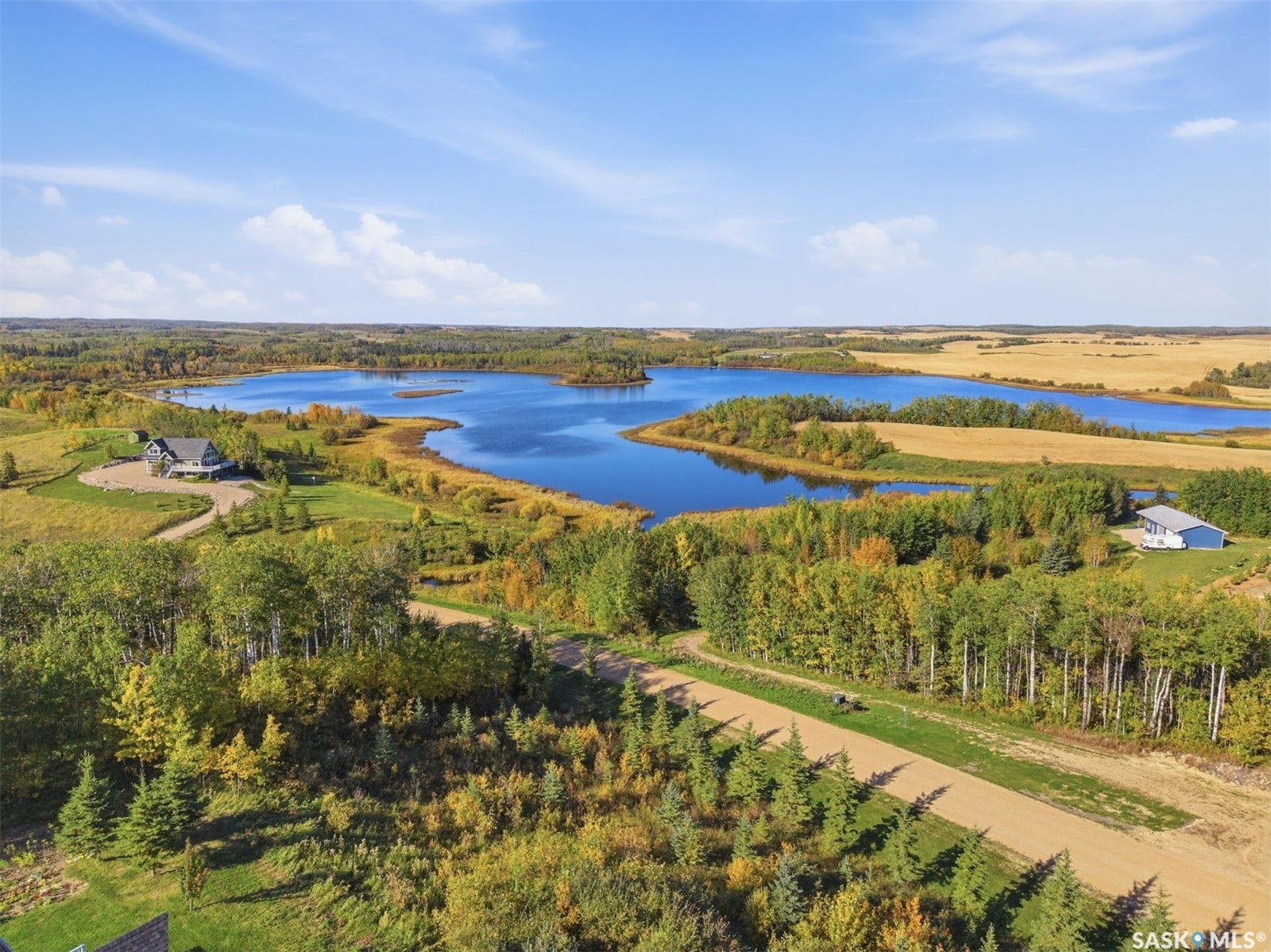 Expansive land featuring a large body of water, natural terrain, and distant properties