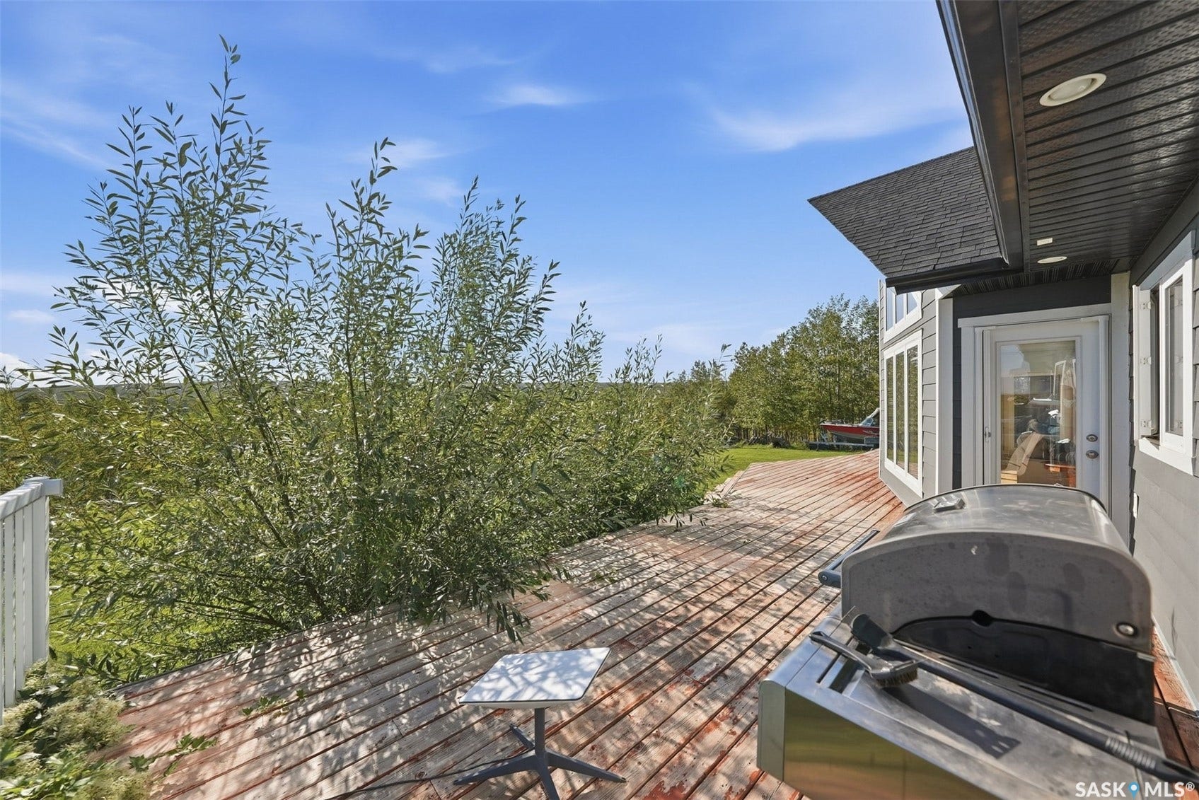 Expansive outdoor deck with wood-finish planks, providing ample space for outdoor living