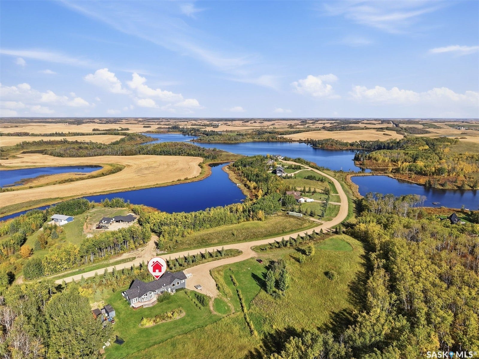 Expansive property featuring a single-story residence, surrounding lush green landscaping, and numerous bodies of water