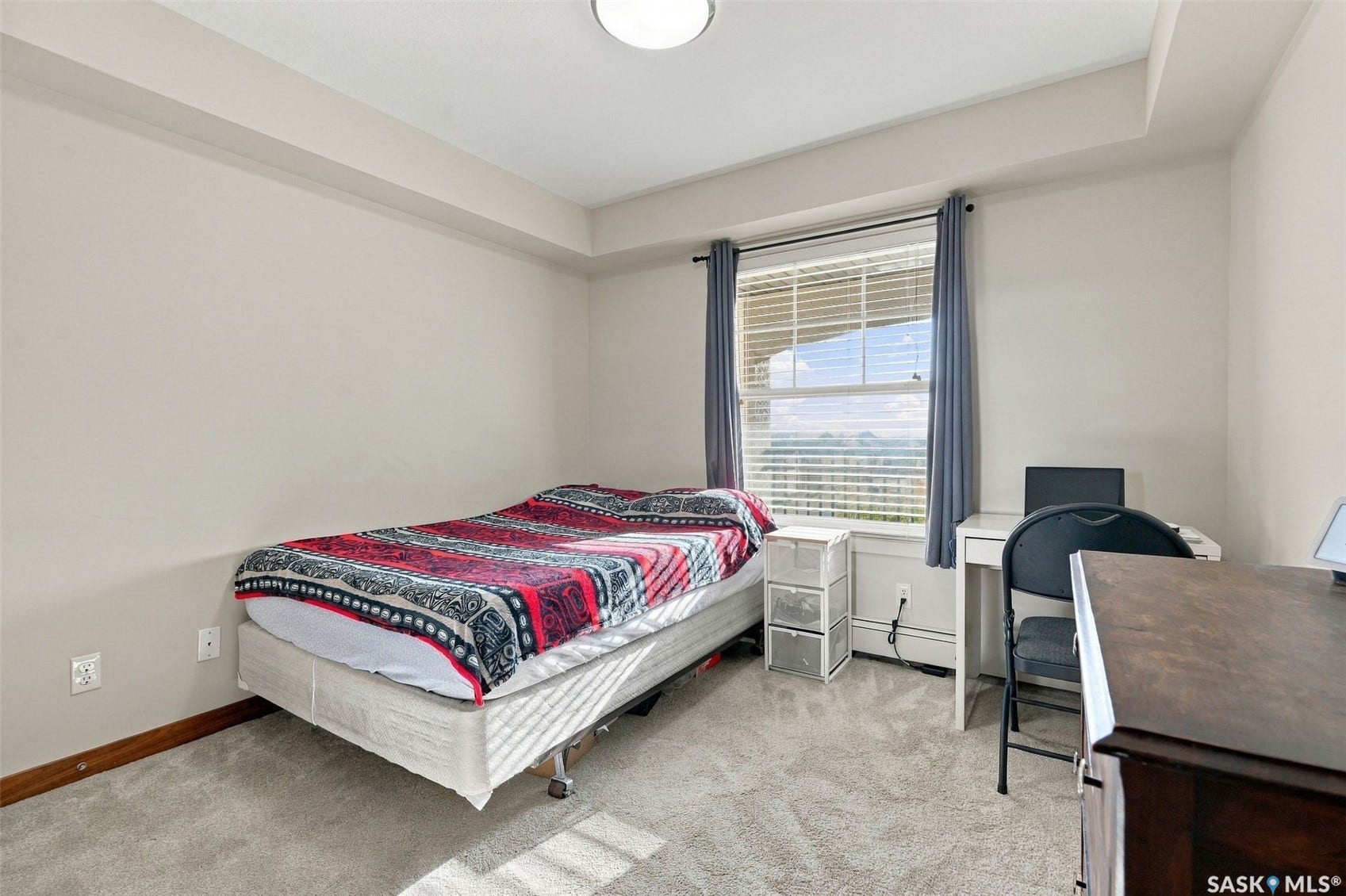Light-toned wall finishes, carpeted flooring, and a window with blinds