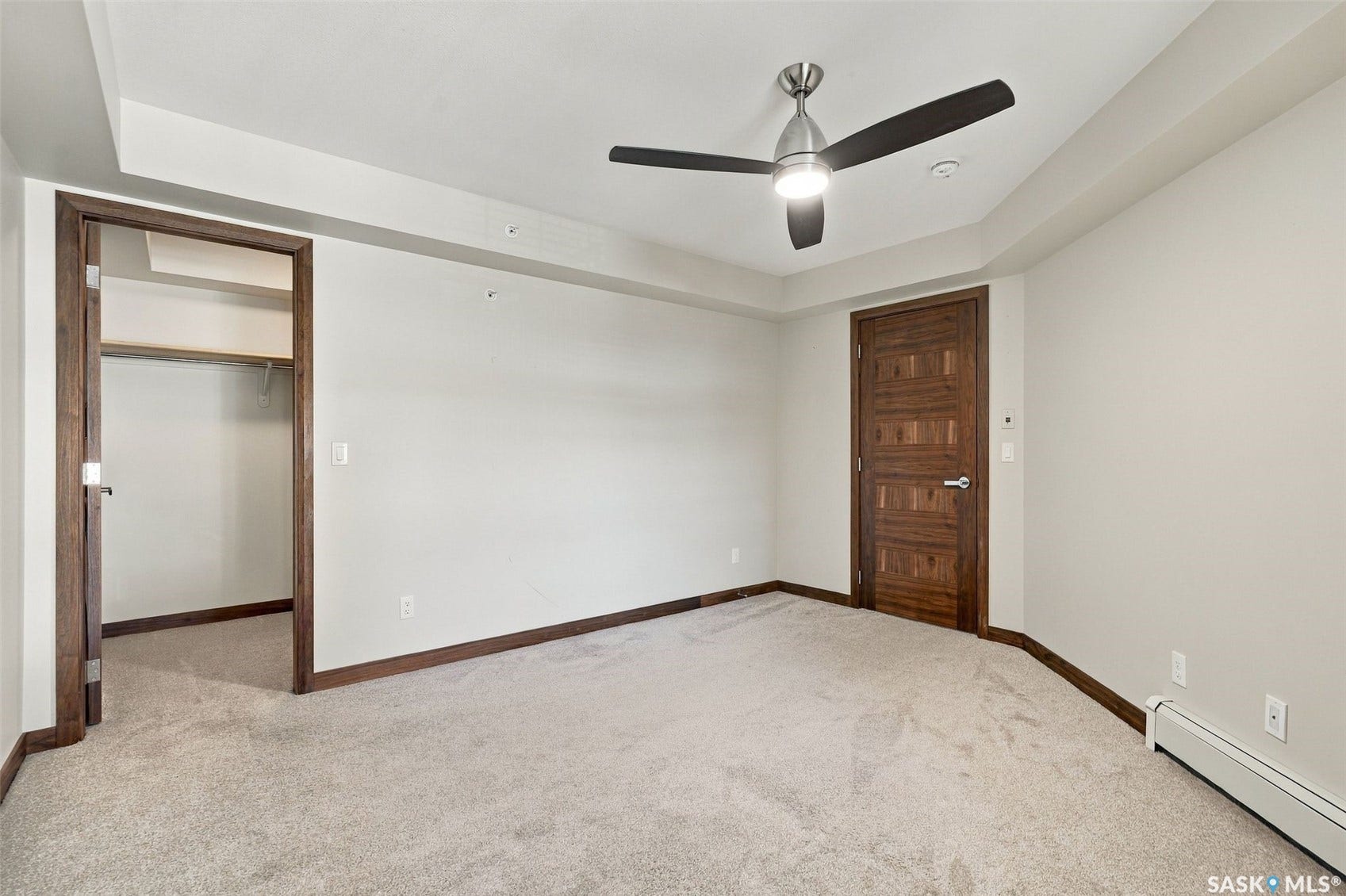Soft neutral carpeting, contemporary ceiling fan with integrated lighting, wood-finish interior doors, integrated closet shelving, and baseboard heating