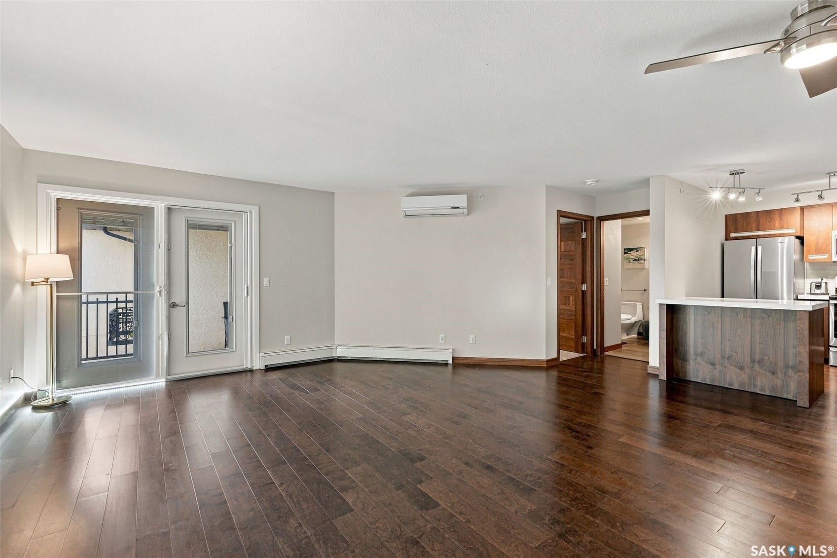 Wood-finish flooring throughout, with a built-in kitchen island featuring a light-toned countertop