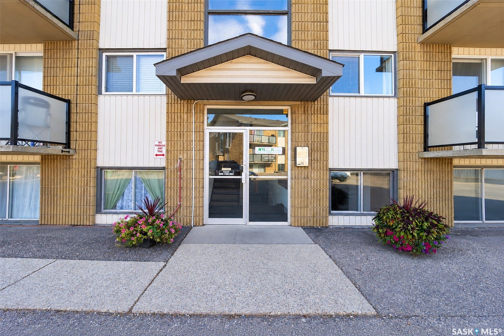 Building exterior featuring textured yellow brick and white vertical siding