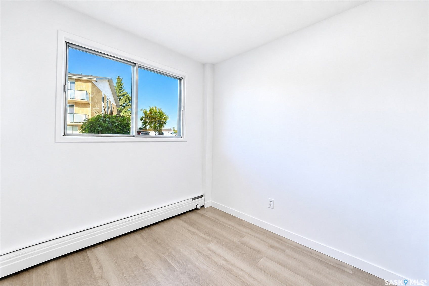 Wood-finish flooring, white walls, and a sliding window with a white frame