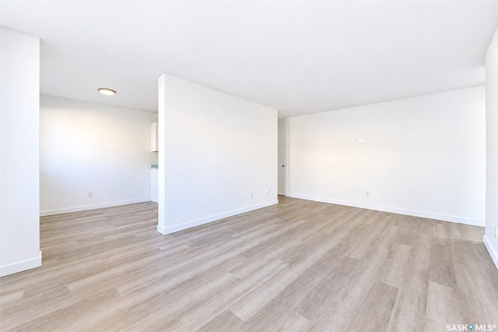 Expansive open-concept living area featuring wood-finish flooring, recessed lighting, and a neutral color palette