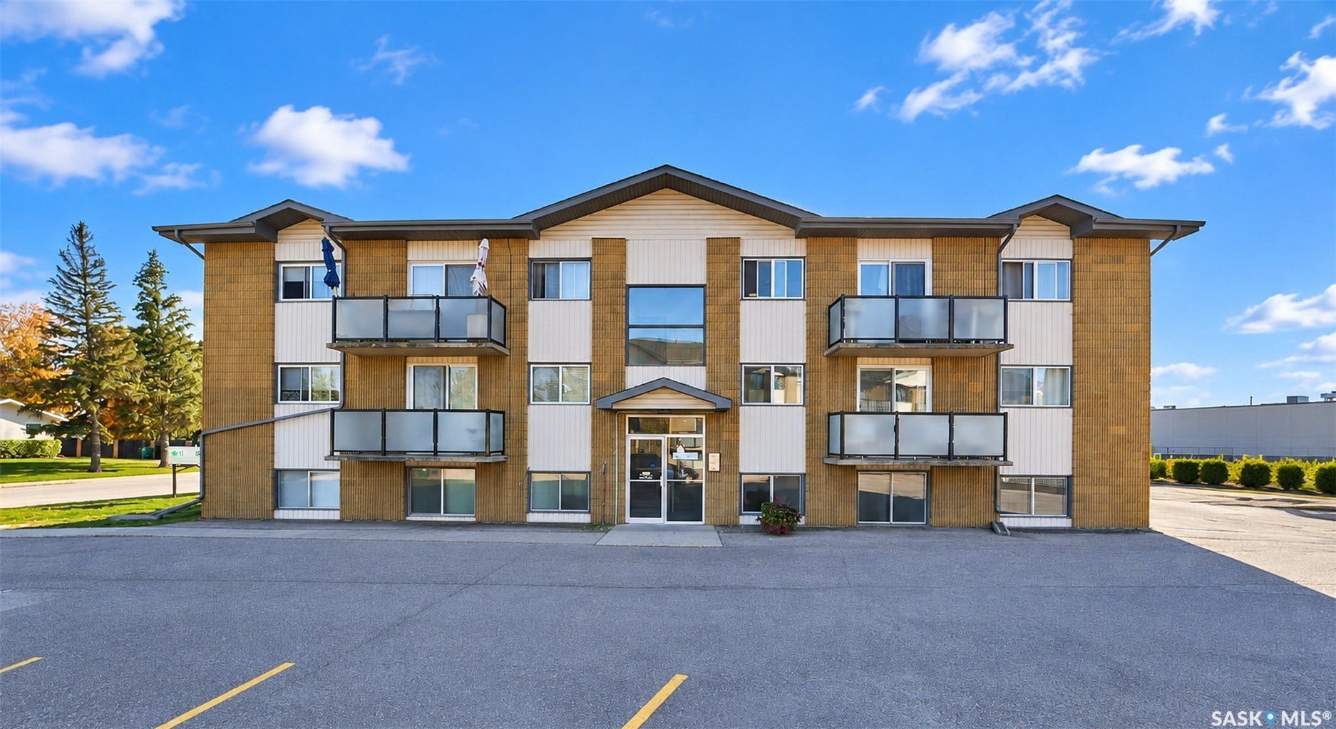 Three-story multi-unit building featuring brick and siding exterior
