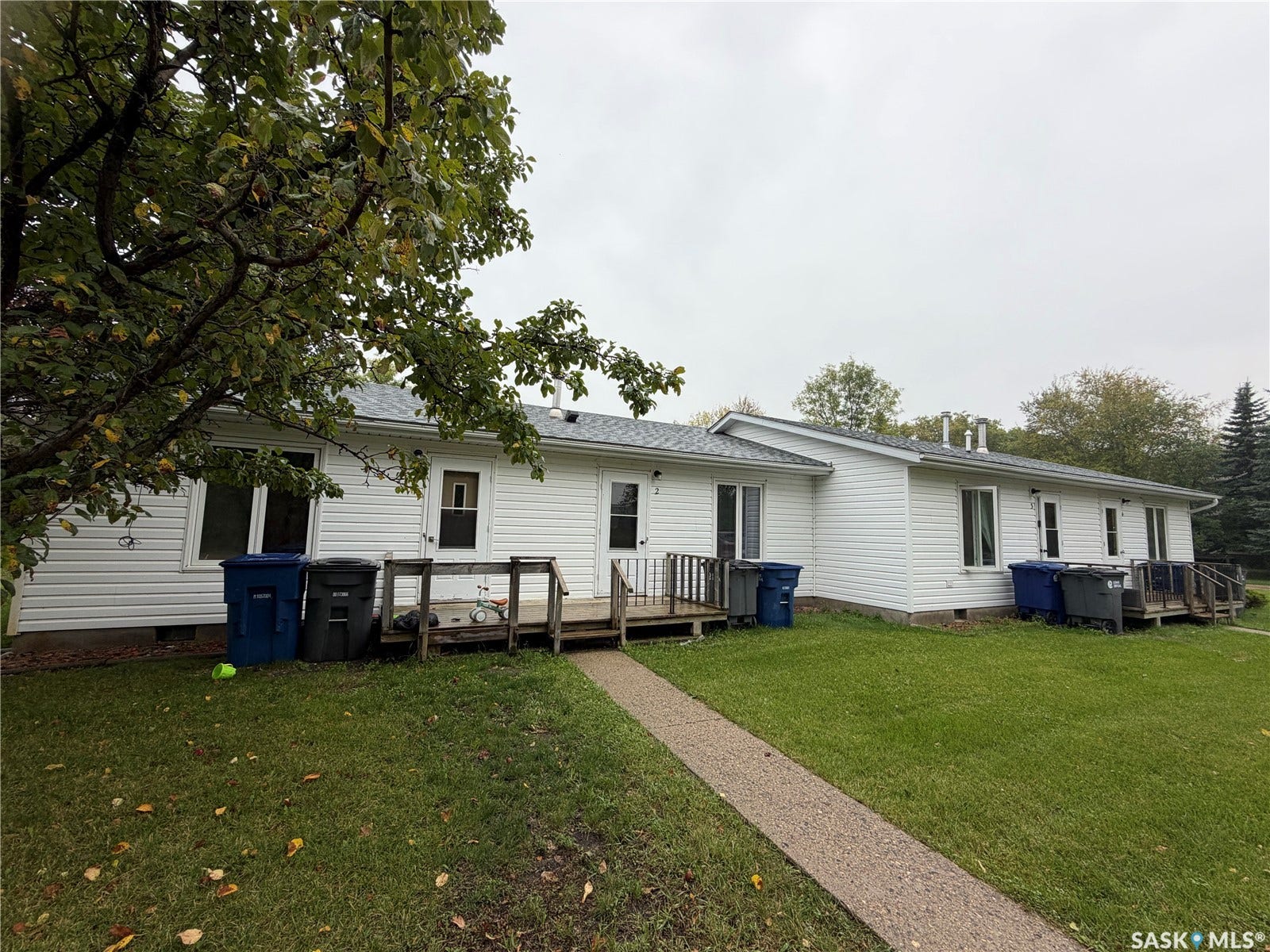 301 2nd Street, #1-10, Kennedy SK S0G 2R0 White vinyl siding exterior with multiple windows and two wooden deck areas