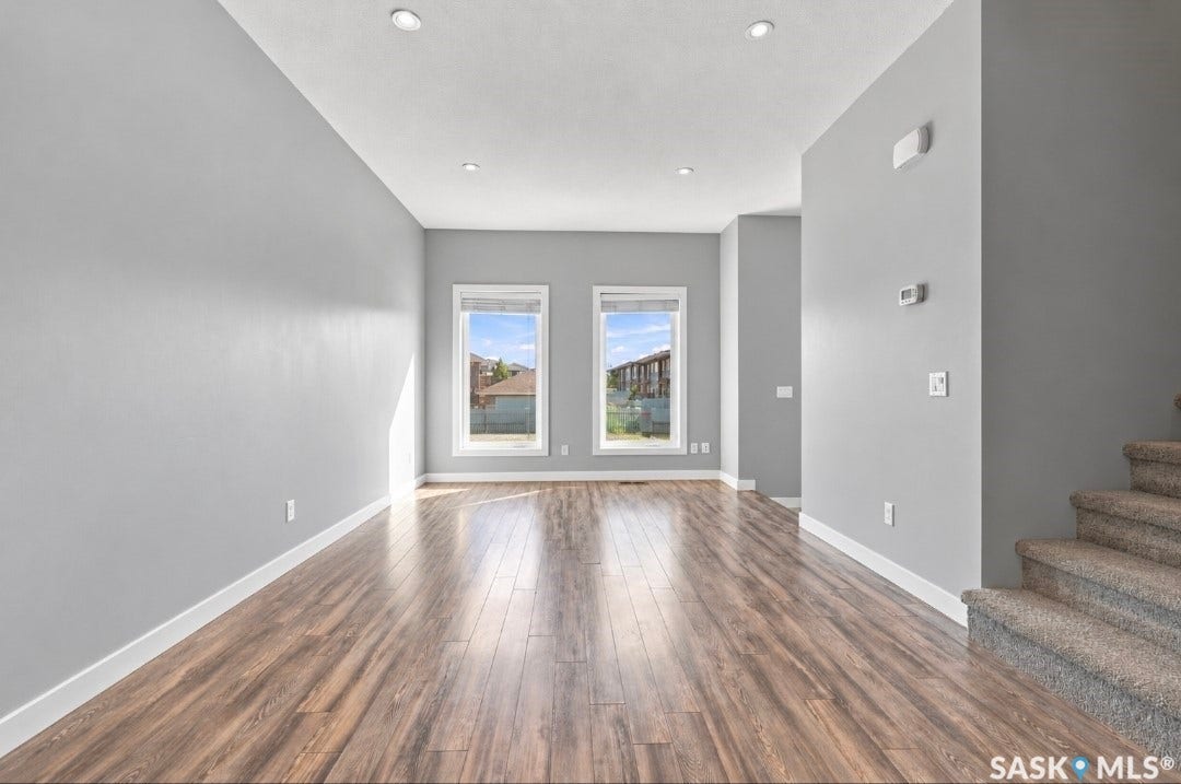 Spacious interior featuring wood-finish flooring, recessed ceiling lighting, and two windows with white trim
