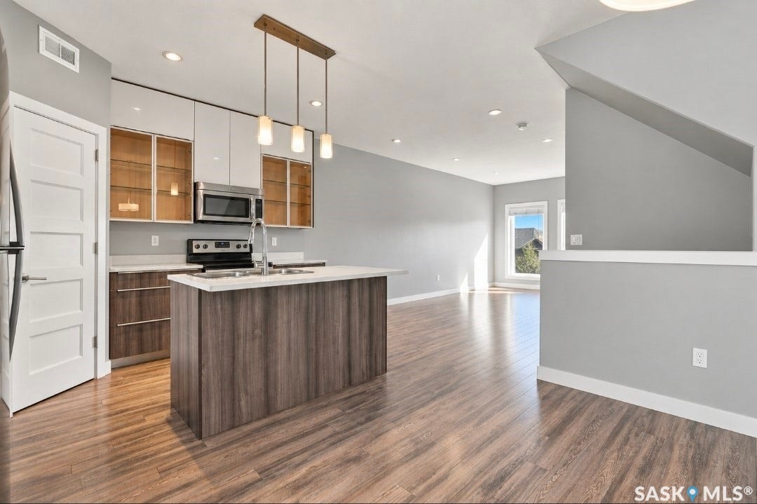 Kitchen featuring a center island, stainless steel appliances, wood-finish flooring, and recessed lighting