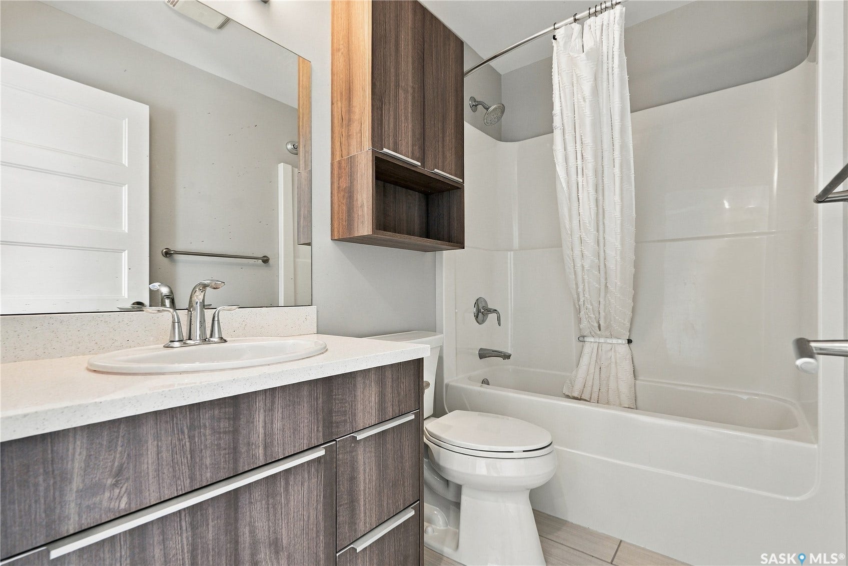 Wood-finish vanity with a light-toned countertop and integrated sink