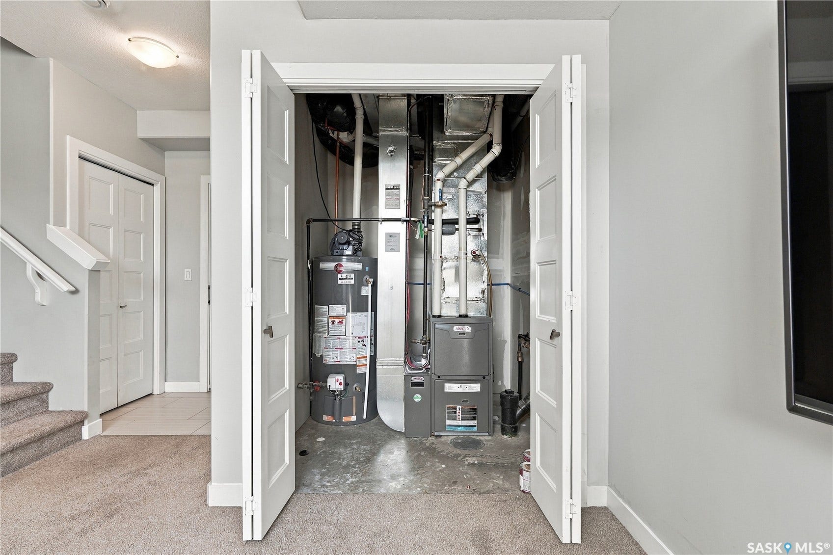 Utility closet featuring a water heater and furnace unit