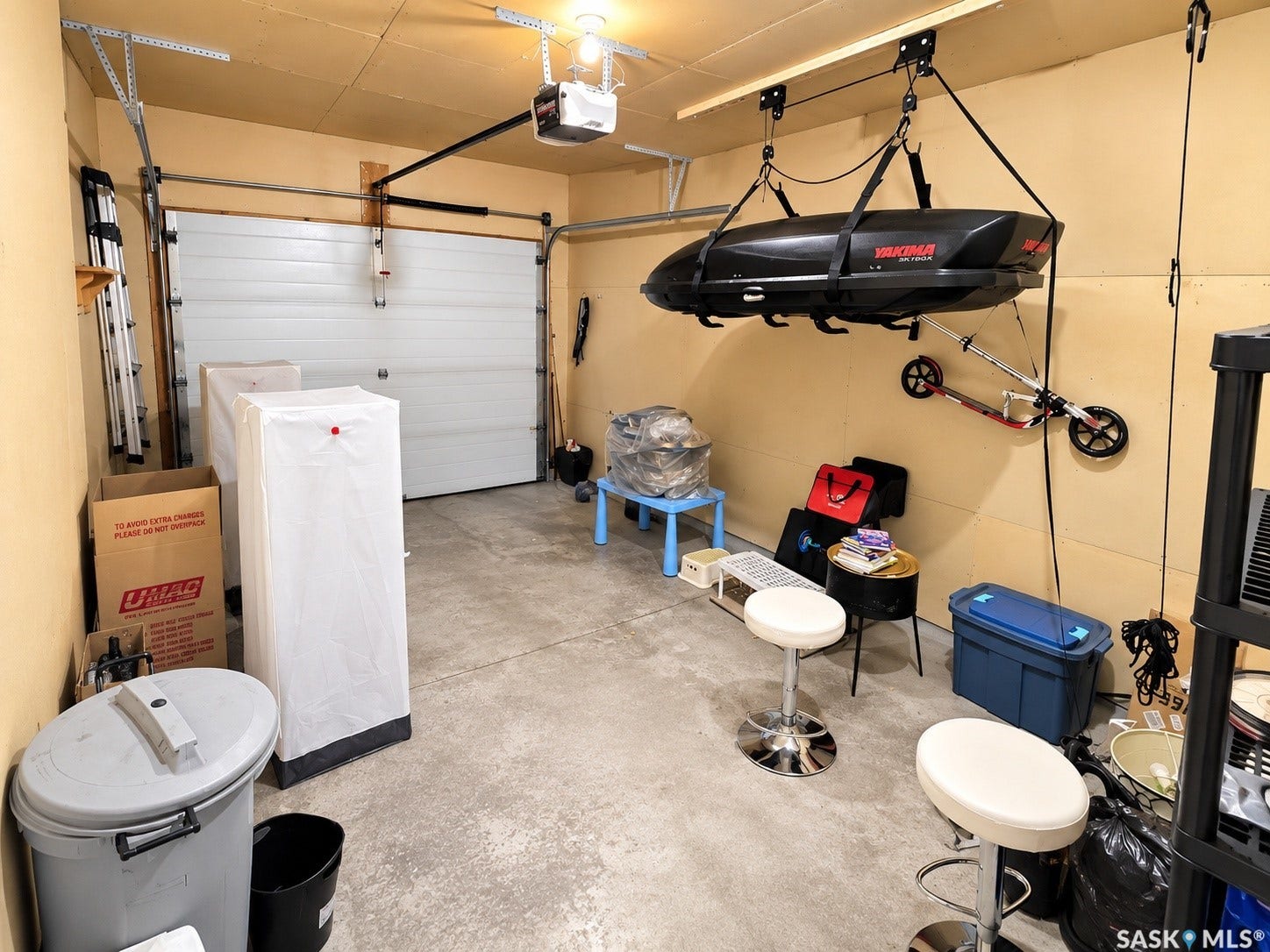 Attached garage featuring an automatic overhead door opener and concrete flooring