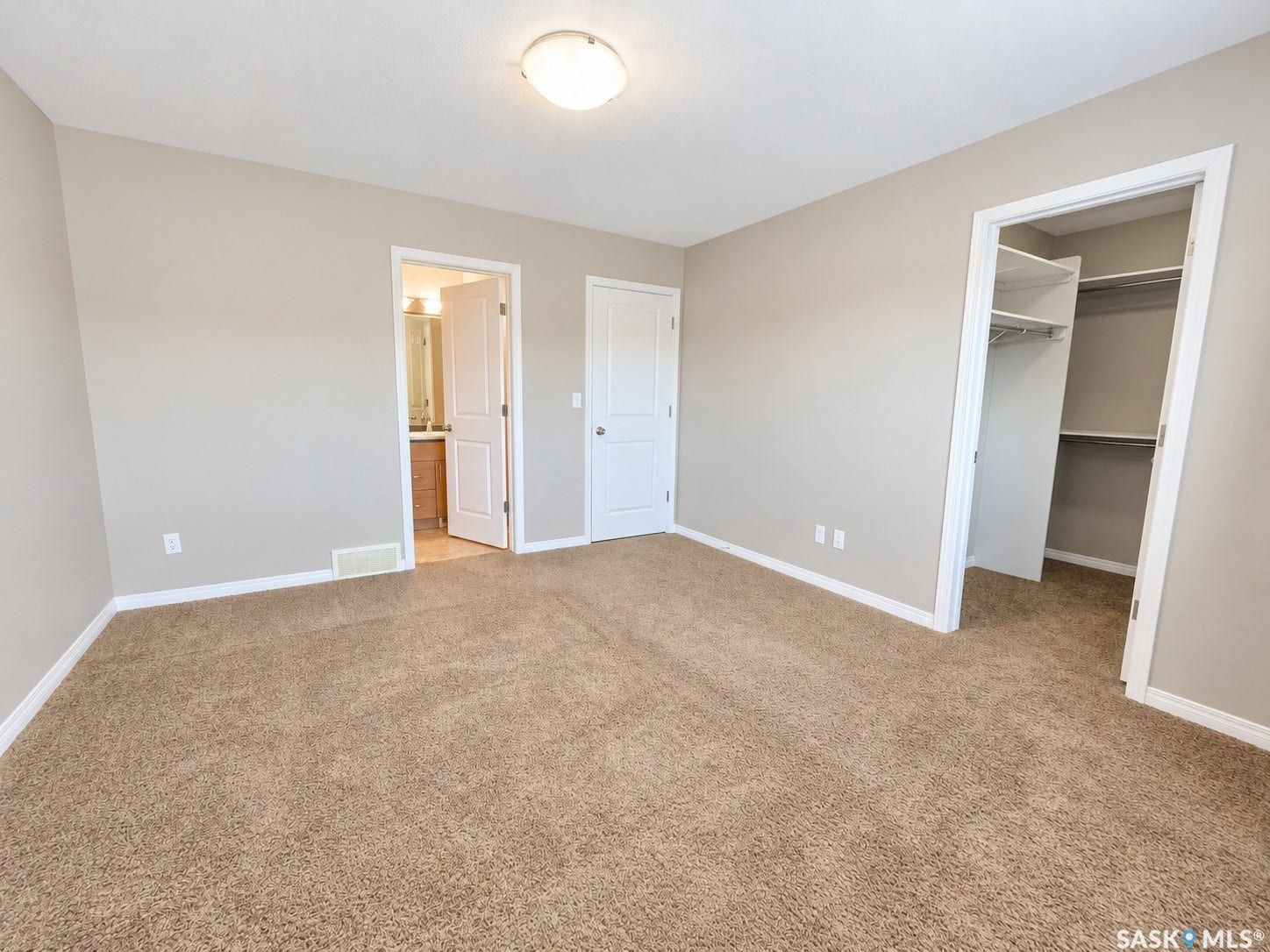 Carpeted room with neutral wall tones, flush mount ceiling light, and white trim