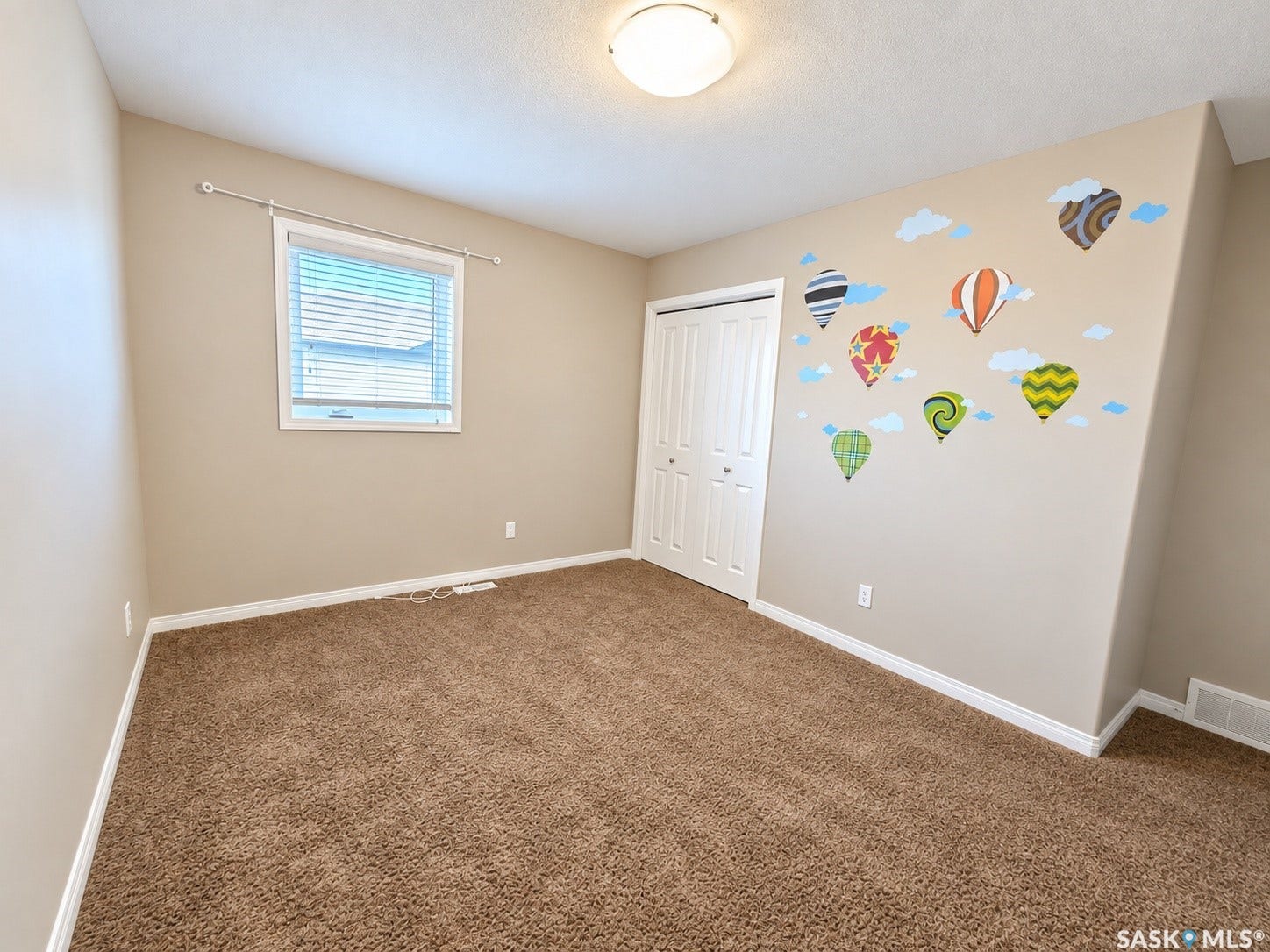 Wall-to-wall carpeting, bi-fold closet doors, and a flush mount ceiling light fixture