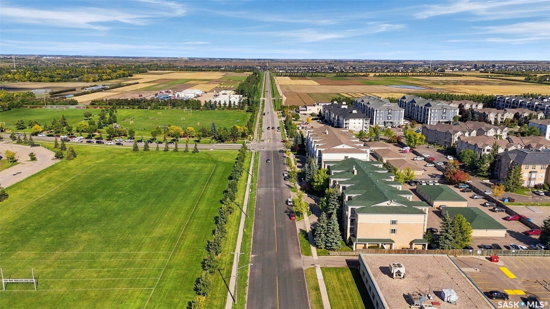 Expansive green spaces and athletic fields, surrounded by residential buildings and established street networks