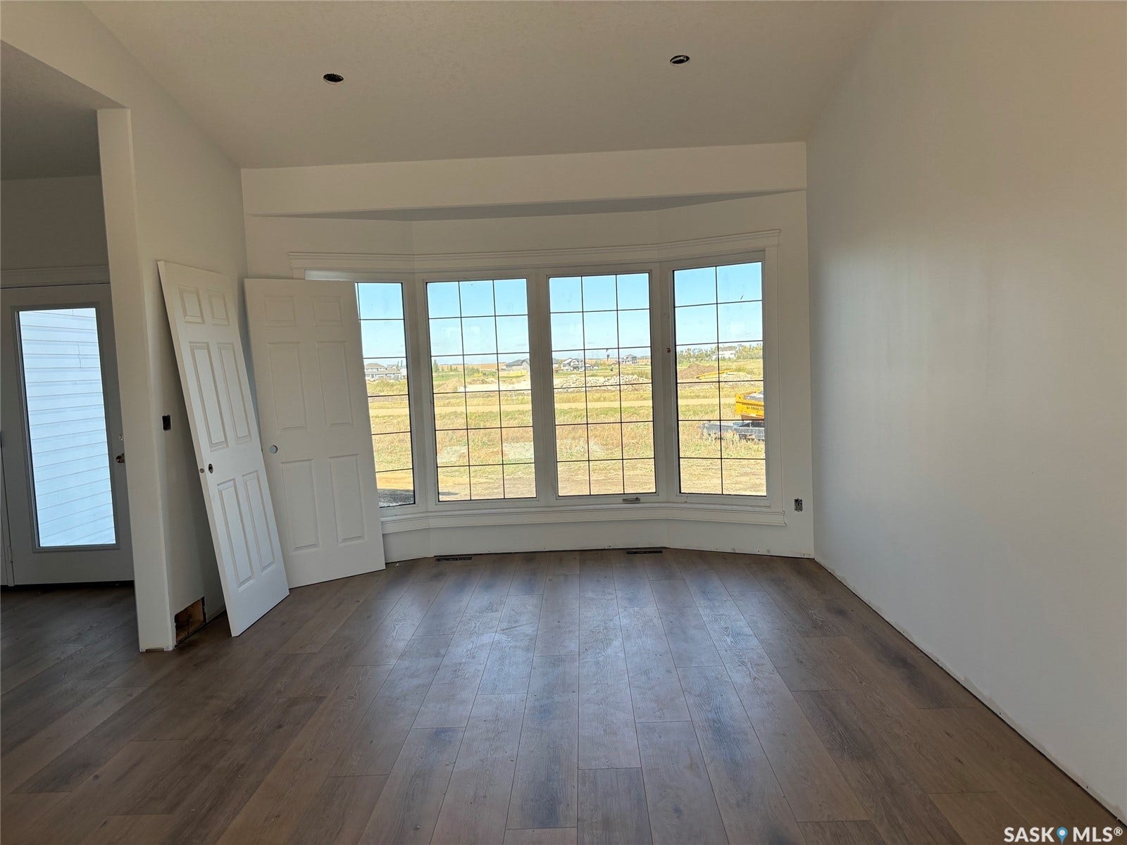 Bay window with multiple panes, wood-finish flooring, and crisp white wall finishes