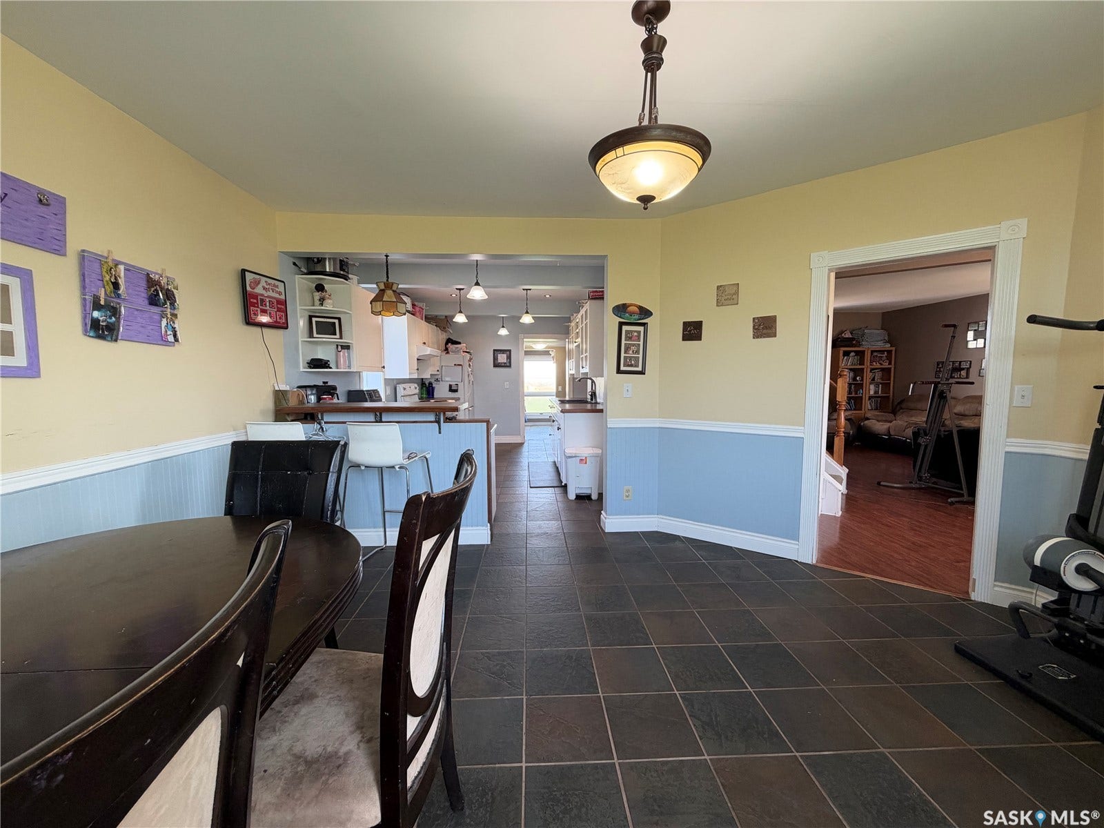 Tile flooring, recessed lighting, built-in breakfast bar, open concept layout, and a decorative pendant light