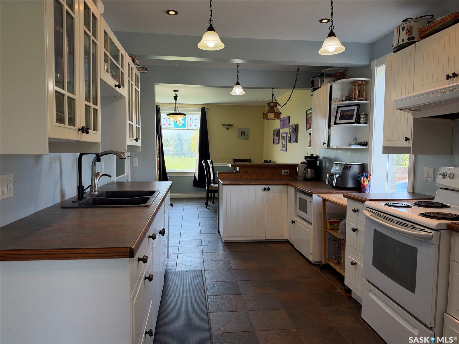 Kitchen featuring white cabinetry, dark wood-finish countertops, and tile flooring