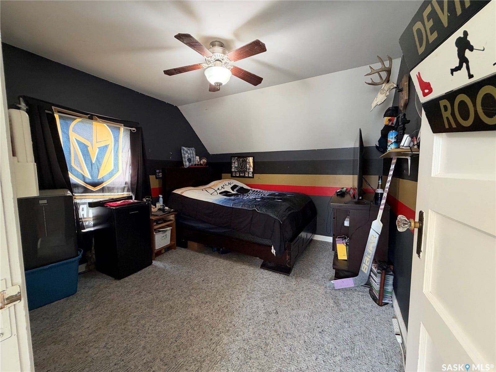 Sloped ceiling room featuring a ceiling fan with integrated lighting, wood-finish bed frame, and carpeted flooring