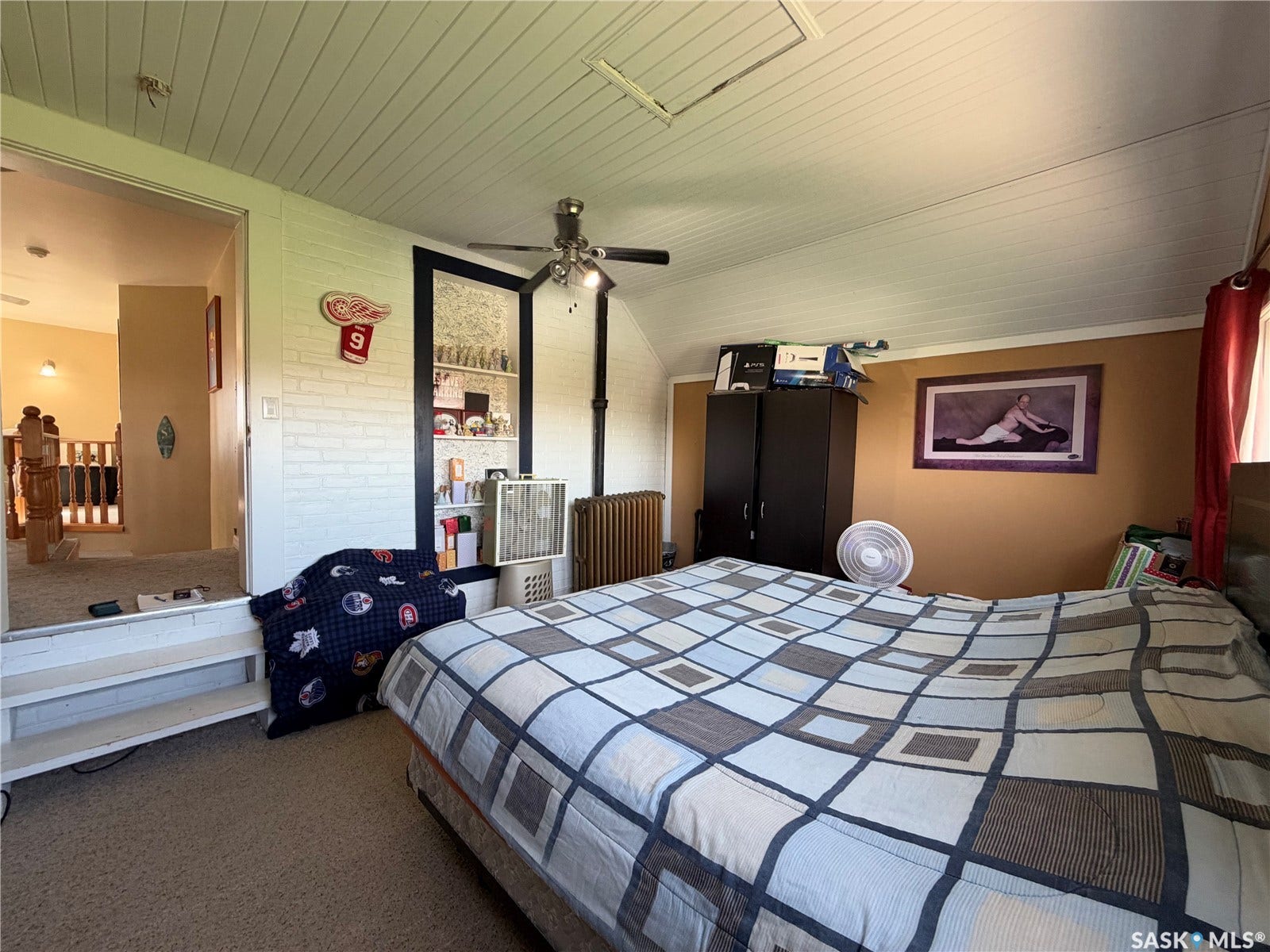 Vaulted ceiling with beadboard paneling and a ceiling fan